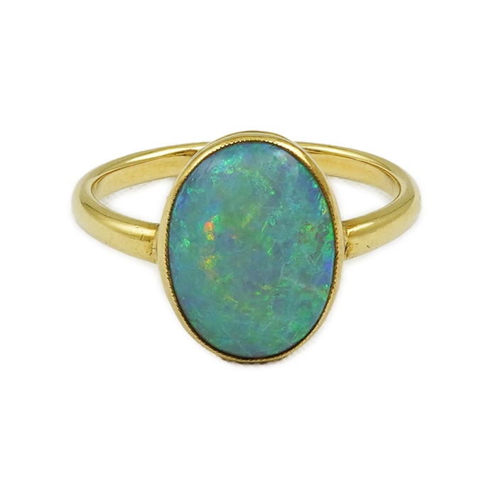 An 18ct gold and single stone oval cabochon opal set ring